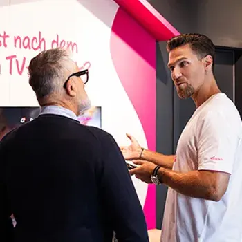 Berater erklärt einem Kunden im Shop Mobilfunk- und Tarifoptionen am Display
